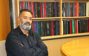Professor Meihana Durie at his office, the books are bound PhD thesis from a range of Māori scholars.