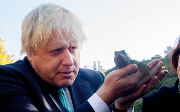 Boris Johnson inspects a tuatara during his visit to Zealandia wildlife sanctuary.