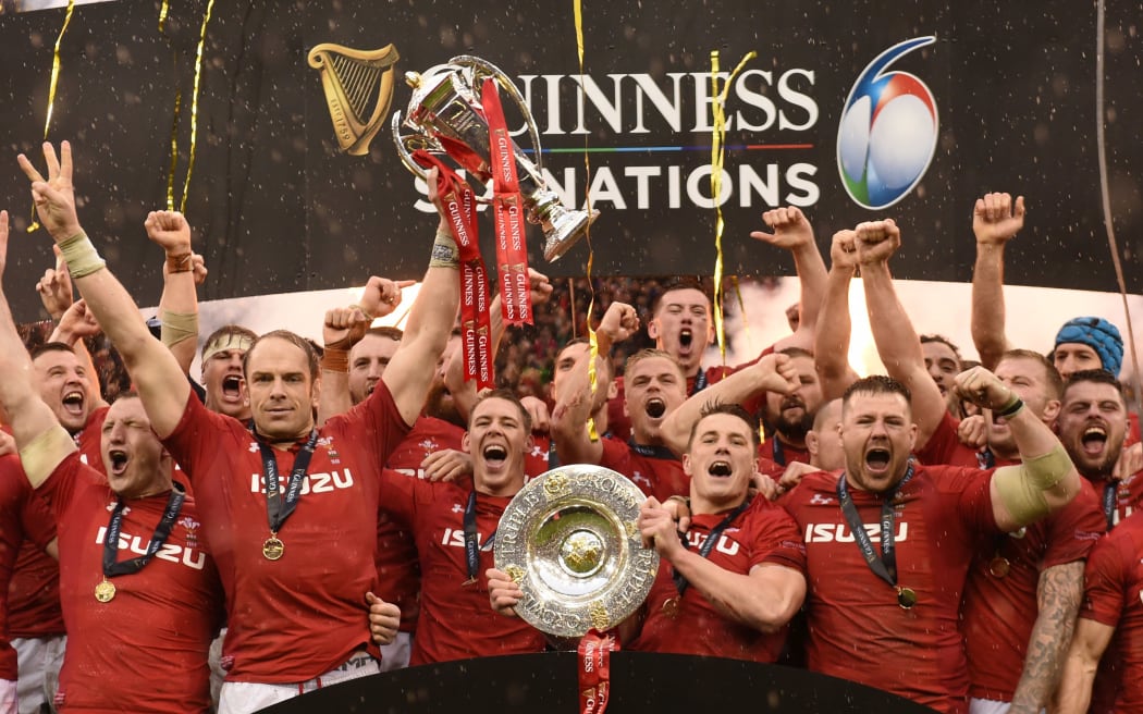 Alun Wyn Jones lifts the Six Nations Championship trophy and Jonathan Davies raises the Triple Crown. 2019.