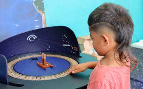 A child learns about planets on orbit as part of Otago Museum's Tūhura Tuarangi Showcase.