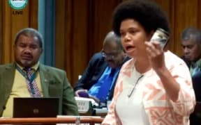 Opposition MP Lenora Qereqeretabua waves a canned fish during her address on the National Budget in Parliament.