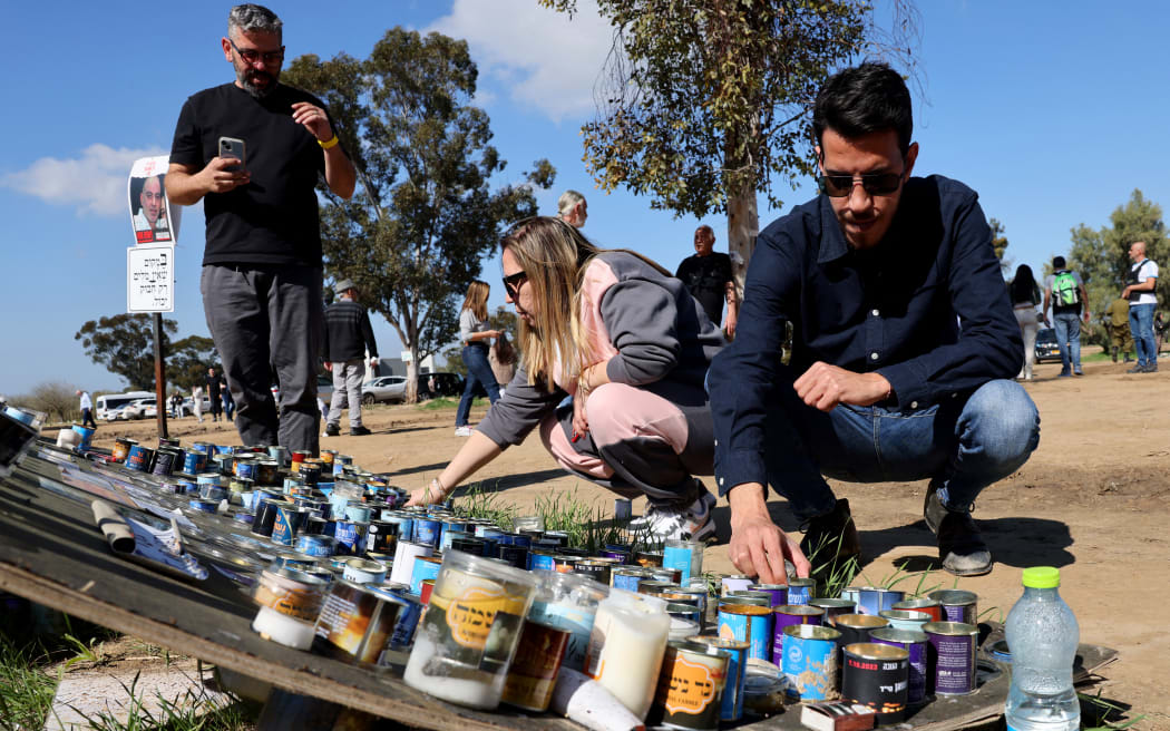 People light candles in memory of youths taken captive or killed by Hamas militants during the attack on revellers attending the Supernova music festival on October 7, 2023, at the site where the event took place near Kibbutz Reim in southern Israel, on February 7, 2024, as the war between Israel and the militant Hamas group in Gaza continues. (Photo by JACK GUEZ / AFP)