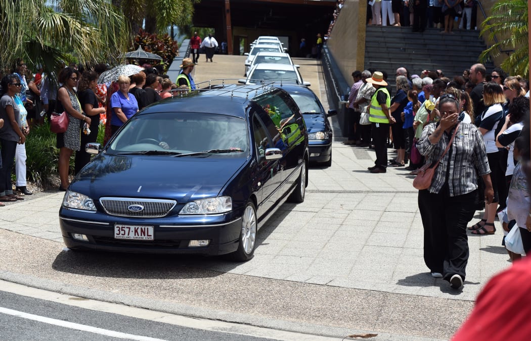 A cortege headed by eight hearses carrying the coffins of eight children leave a memorial service at the Cairns Convention Centre.