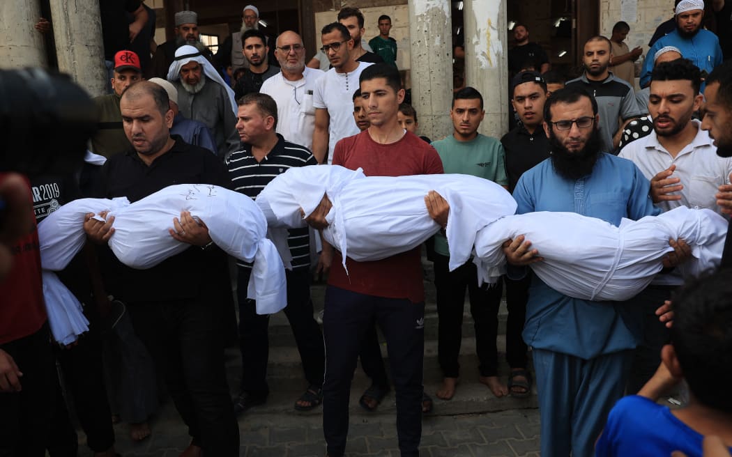 Relatives carry the bodies of children from the Abu Quta family during a funeral on 8 October, 2023, after they were killed in Israeli strikes on the Palestinian city of Rafah in the southern Gaza Strip.