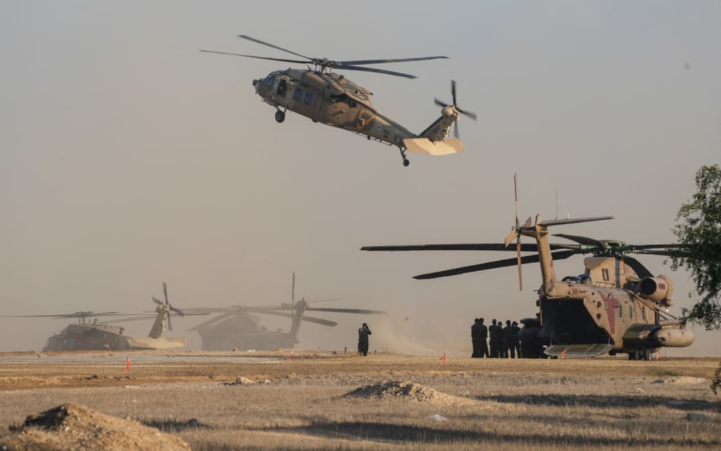 Israeli military helicopters wait in preparation to take hostages released by Hamas in Gaza to hospitals in Israel after they arrive in the southern Reim army base.