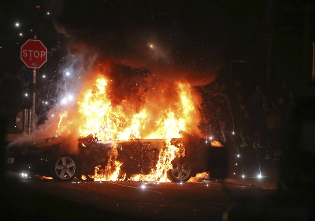 A car burns after petrol bombs were thrown at police in Creggan, Londonderry, in Northern Ireland, on April 18, 2019.