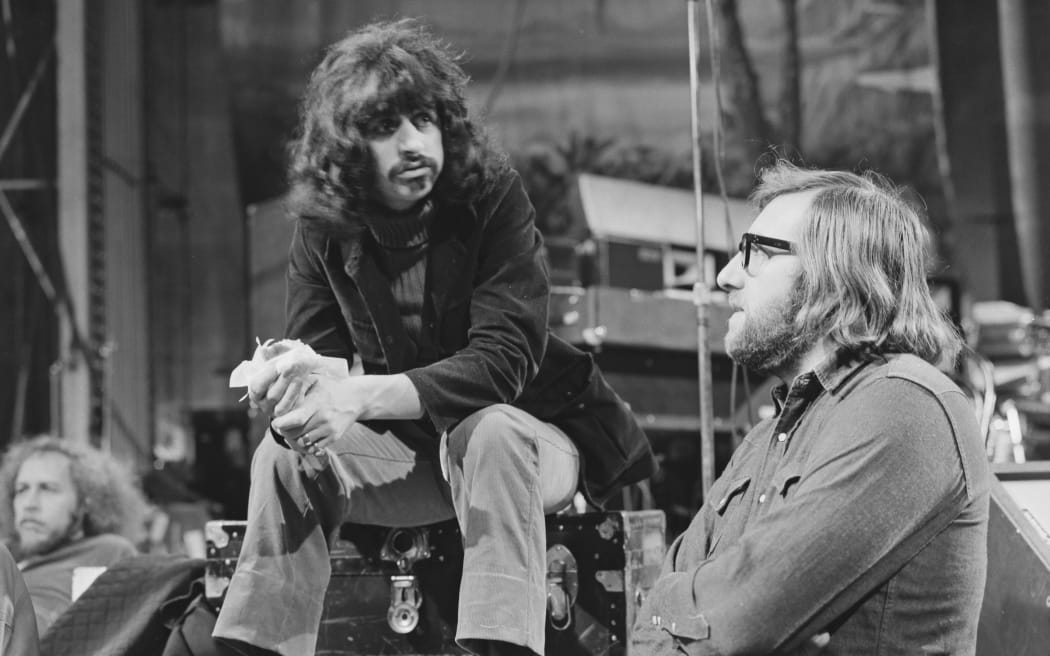 English drummer Ringo Starr of The Beatles talks with Beatles assistant and roadie Mal Evans (1935-1976) during a rehearsal at the Royal Albert Hall in London in February 1971. Ringo Starr is rehearsing with American group Mothers of Invention ahead of their planned performance of music from the film '200 Motels' at the Hall on 9th February.