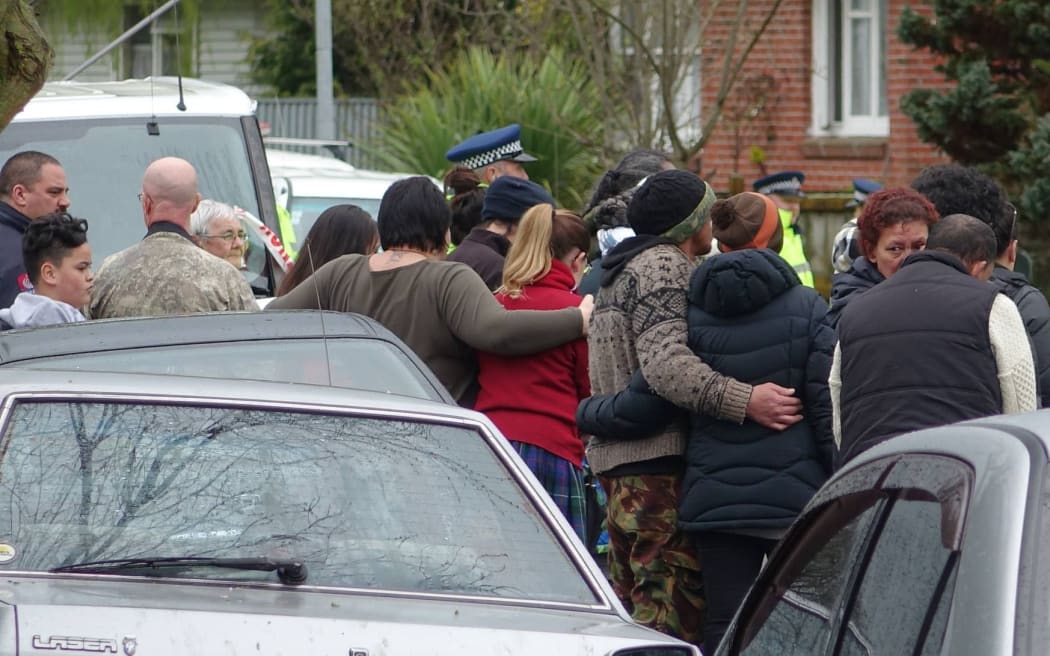 Whanau watch on as the bodies of a girl and her grandmother are taken from a Palmerston North house.