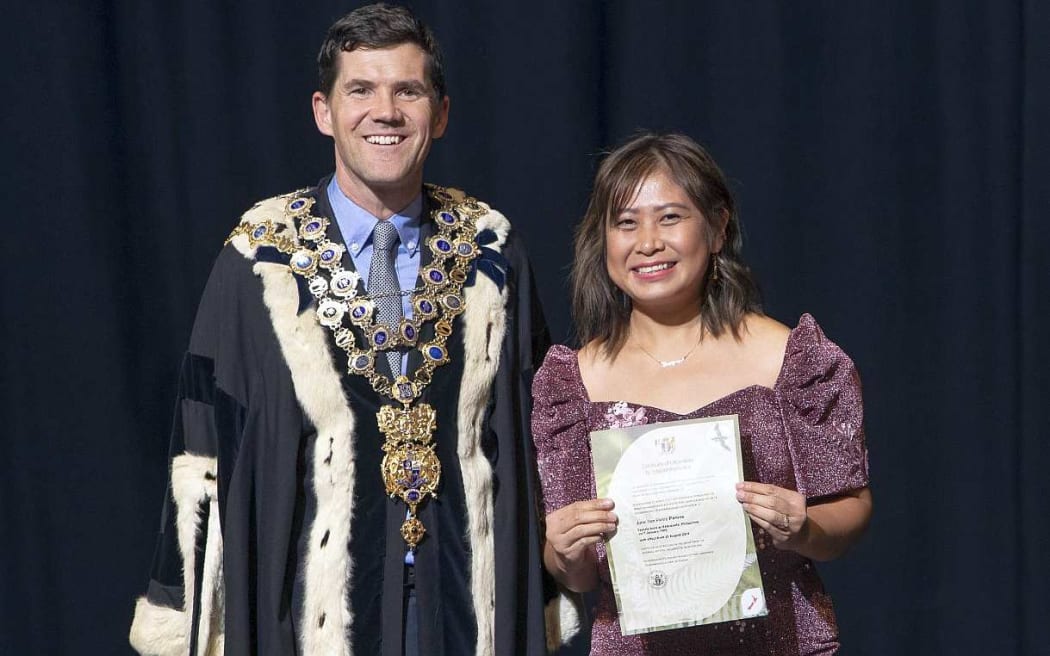 Mayor in full regalia and woman in formal long outfit.