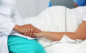 medical professional holding pregant woman's hand