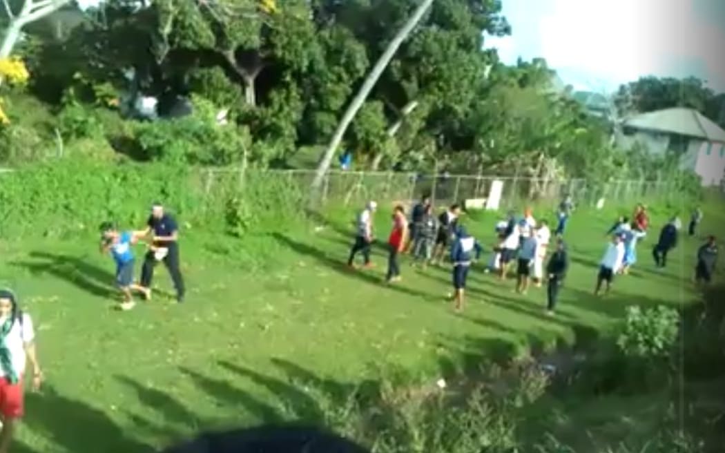 A screenshot from a video posted to facebook which allegedly shows a police officer in Tonga repeatedly punching and kicking a young boy.