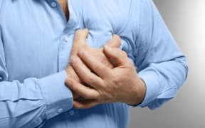 Elderly man holding hands on chest suffering from heart attack, closeup
