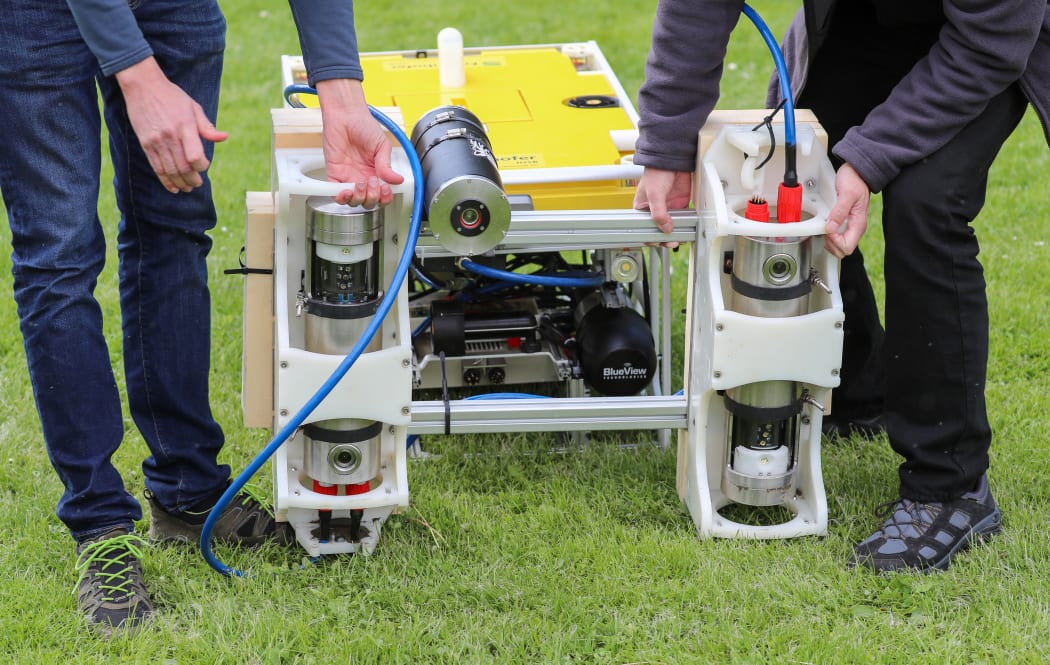 Members of a research group mounting a high-resolution 3D laser to scan a lake bed in Germany.