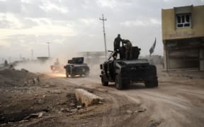 Members of the Iraqi Counter Terrorism Service (CTS) drive near the village of Bazwaya, on the eastern edges of Mosul, tightening the noose on Mosul as the offensive to retake the Islamic State group stronghold entered its third week on October 31, 2016.