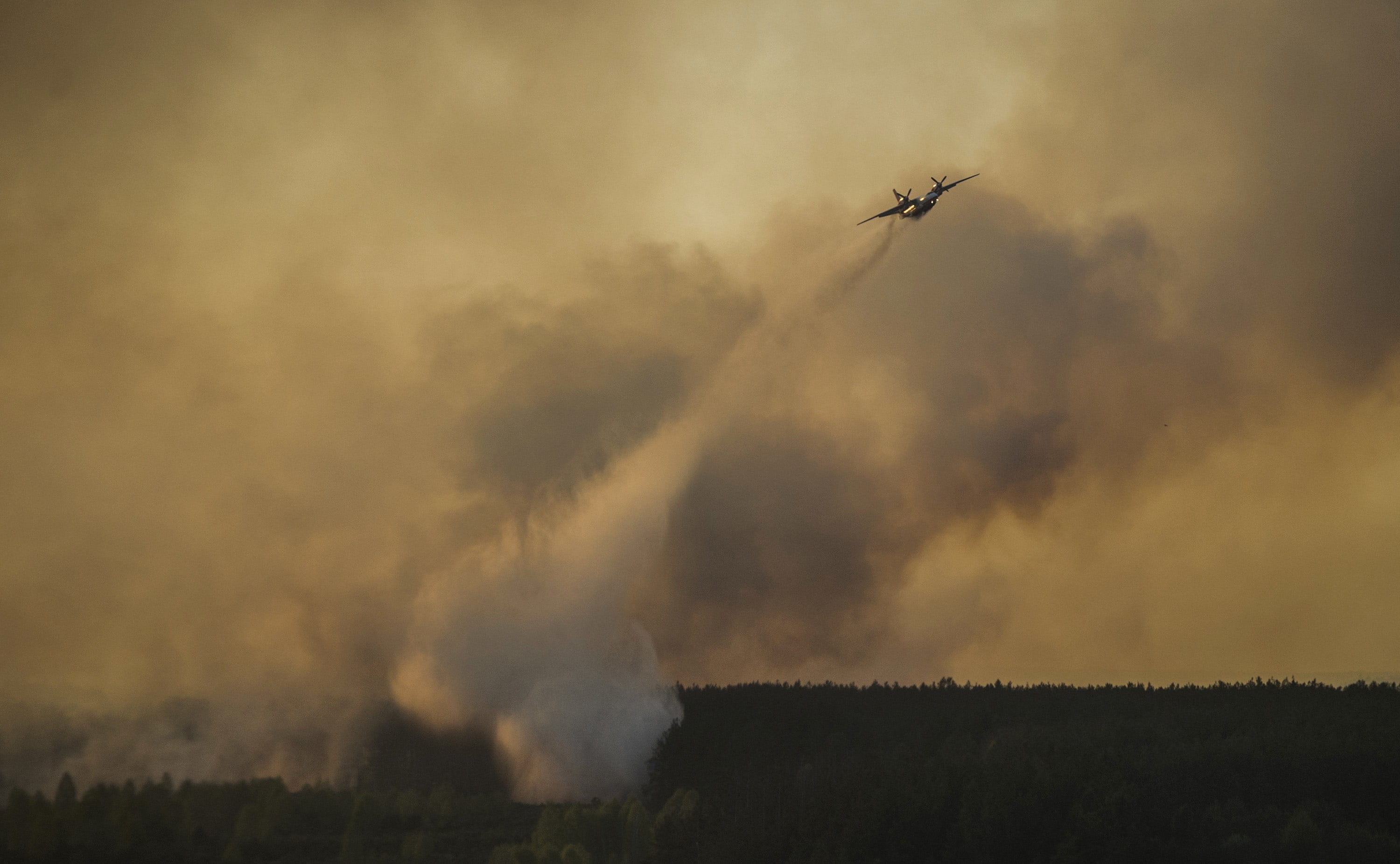 A plane drops water on a forest fire near Ukraine's old Chernobyl nuclear plant.