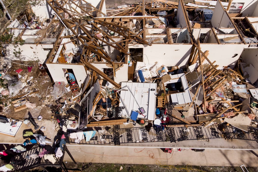 A man works though the remains of an apartment in the aftermath of Hurricane Michael.