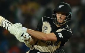 Mitchell Santner sweeps against India at the T20 World Cup.