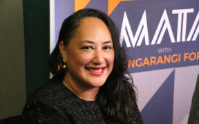Auckland mayoral candidate Kerrin Leoni poses for a picture in front of a MATA with Mihingarangi Forbes graphic.