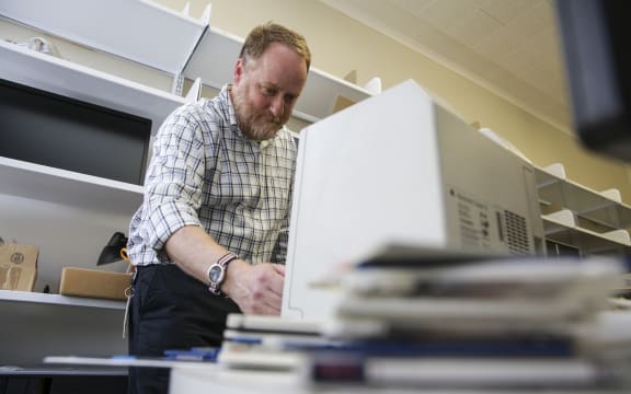 Mick Crouch works with an old-technology floppy disk reader as he preserves New Zealand’s archives