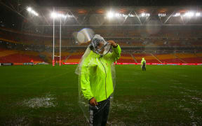 Security guards survey Brisbane's sodden Suncorp Stadium ground.