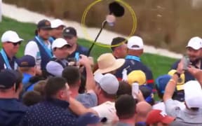 A beer is launched from the Ryder Cup crowd towards Rory and Erica McIlroy. (Supplied)