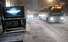 New York traffic moves through lower Manhattan in the pre-dawn hours as a winter storm brings heavy snow, freezing temperatures and strong winds.