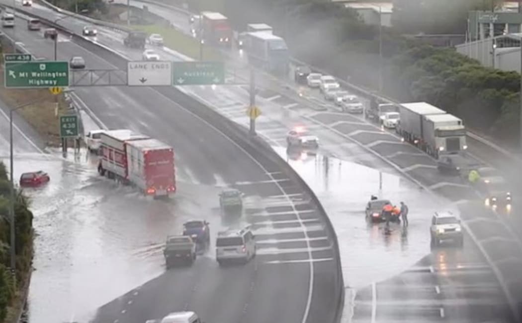 Southbound lanes on Auckland's Southern Motorway are blocked next to the Mt Wellington Highway off-ramp due to surface flooding and a submerged car.