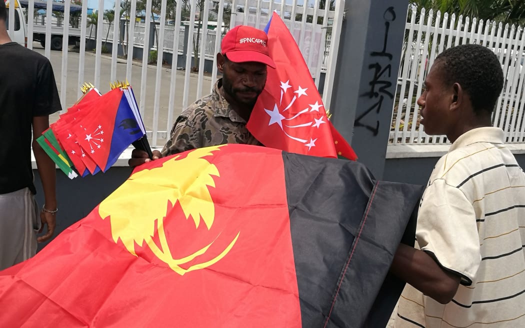 Man hawking national and provincial flags in Papua New Guinea.