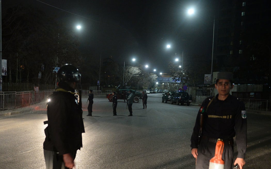 Afghan policemen stand guard near the Serena Hotel.