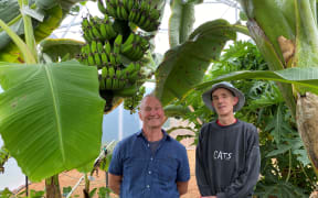 Geoff Mansell (left) with partner Craig in their subtropical greenhouse