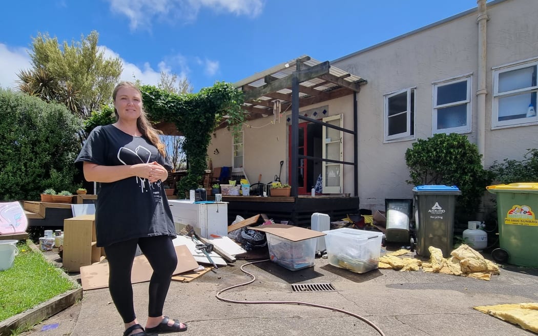 Carla Caldwell at her house in Sandringham with flood damaged belonging shown in the background.
