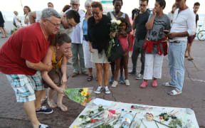 A woman places flowers at a make-shift memorial for victims of the deadly Bastille Day attack in Nice.