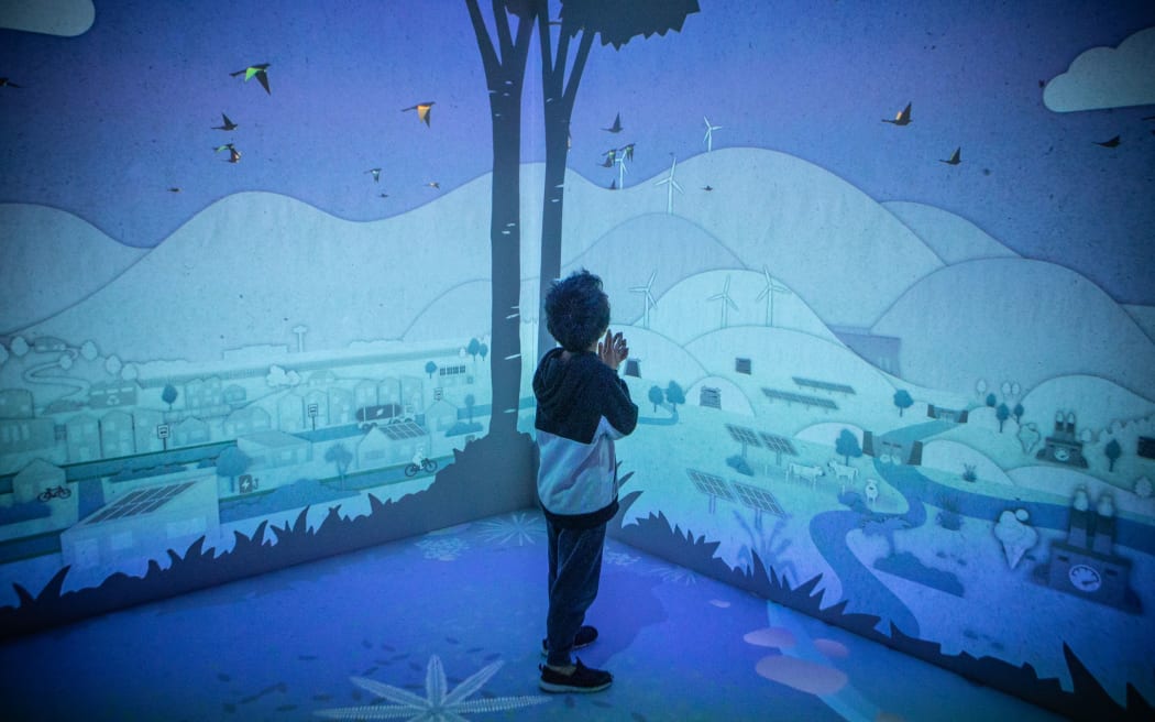 A child explores the interactive room, the Climate Converter, where visitors take actions to turn the tide on climate change.