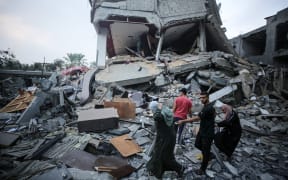 Palestinians gather at the site of Israeli strikes on houses in Deir Balah in the central Gaza Strip, on October 24, 2023, during ongoing battles between Israel and the Palestinian Hamas group.