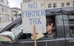 A member of the Groundswell protest holds a sign calling for government to drop its ute tax in Wellington on 20 October 2022.