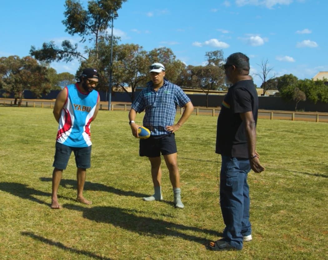 Uncle Des and his nephew Nethaniel teaching Piripi how to play Aussie rules