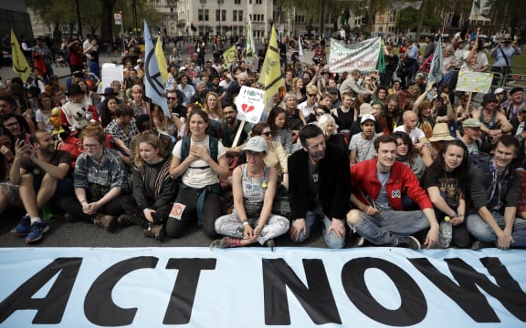 Protesters sit in the road in Parliament Square, in London, on 23 April, 2019, during a climate protest.