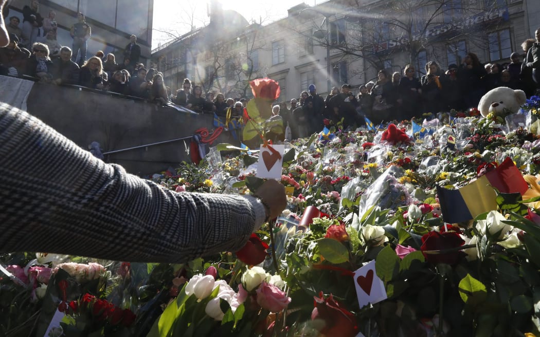 People lay flowers at a memorial ceremony in Stockholm on Sunday. More than 20,000 people attended the vigil.