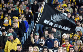 Supporters of the New Zealand women's hockey team cheer on their players 24 September 2000 during the preliminary Olympic hockey match between New Zealand and Australia at the State Hockey Centre in Sydney