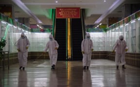 (FILES) In this file photo taken on December 28, 2020 health workers spray disinfectant inside the Pyongyang Department Store No. 1 prior to opening for business, in Pyongyang on December 28, 2020. - North Korea on May 12, 2022 confirmed its first-ever case of Covid-19, with state media declaring it a "severe national emergency incident" after more than two years of purportedly keeping the pandemic at bay. (Photo by KIM Won Jin / AFP)