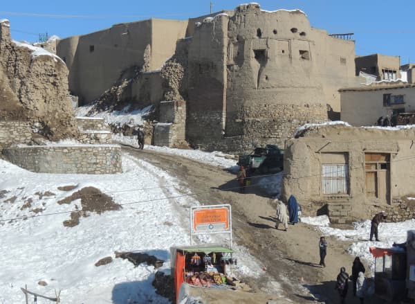 Pedestrians walk past a section of the old city as snow is pictured on the ground in Ghazni province on February 12, 2013. Ghazni, located in eastern Afghanistan along the Kabul-Kandahar road, is one of the thirty-four provinces and one of Afghanistan's major cities with an estimated population of 141,000 people.
