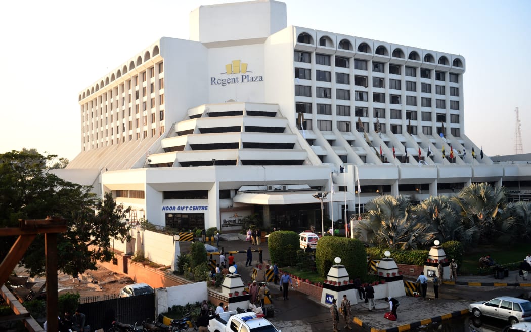 Guests and emergency services stand around outside the Regent Plaza Hotel after the fire.