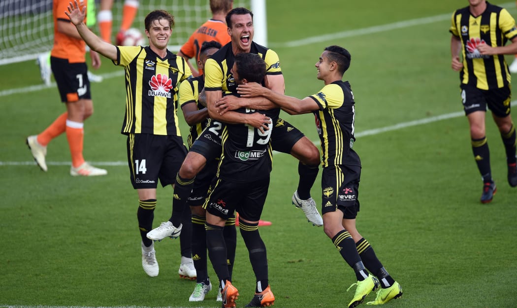 Wellington Phoenix defender Steven Taylor and team-mates celebrate their opening goal against the Brisbane Roar.