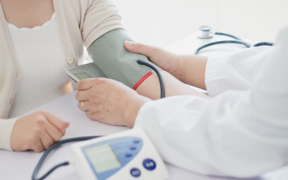 Doctor measures blood pressure of patient.