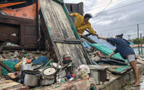 A family salvages belongings from the rubble of their home after it collapsed during Hurricane Melissa’s passage through Santiago de Cuba, Cuba, on 29 October, 2025.