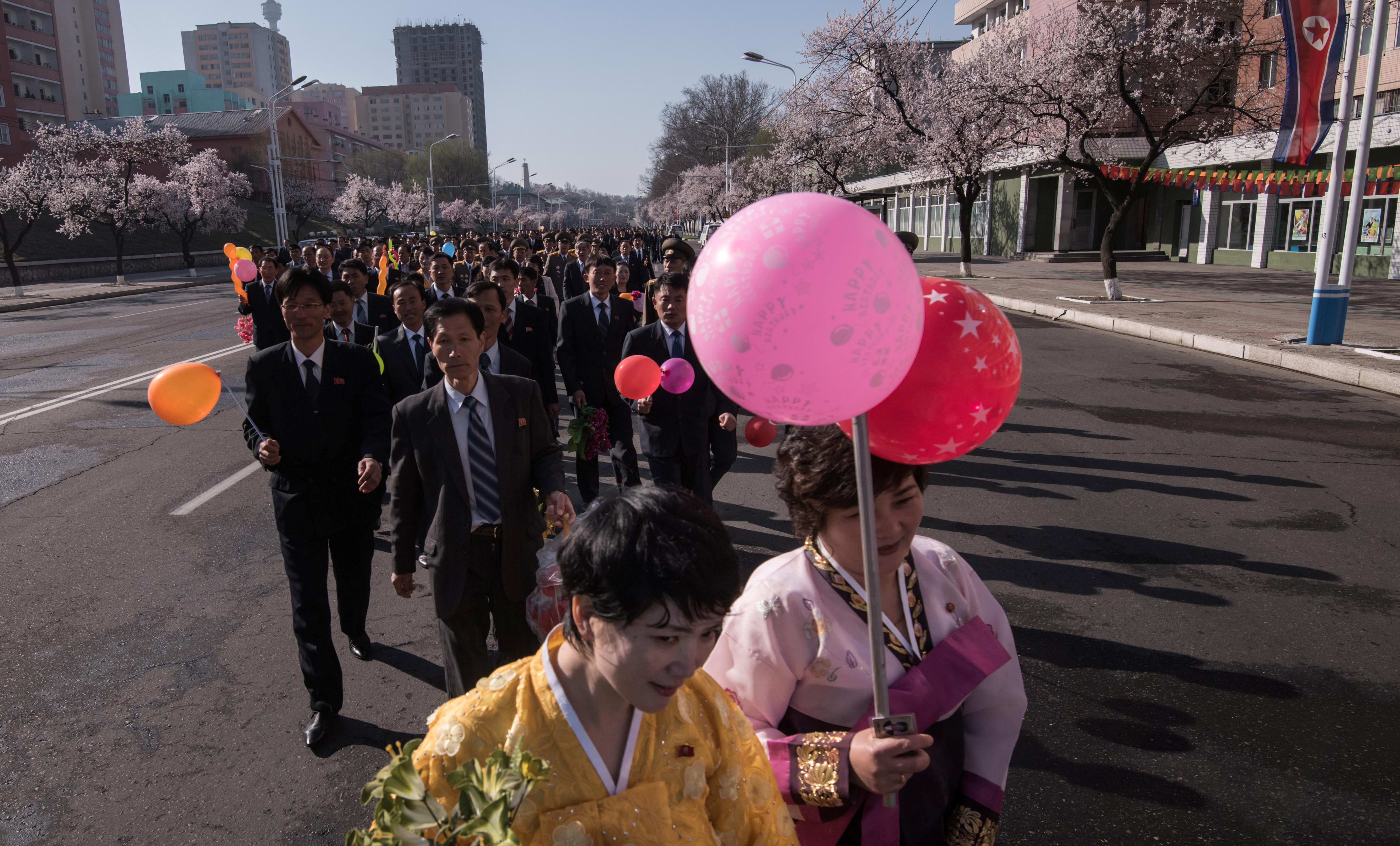 Attendees wearing traditional Korean dress make their way to the opening ceremony for the Ryomyong Street housing development in Pyongyang.