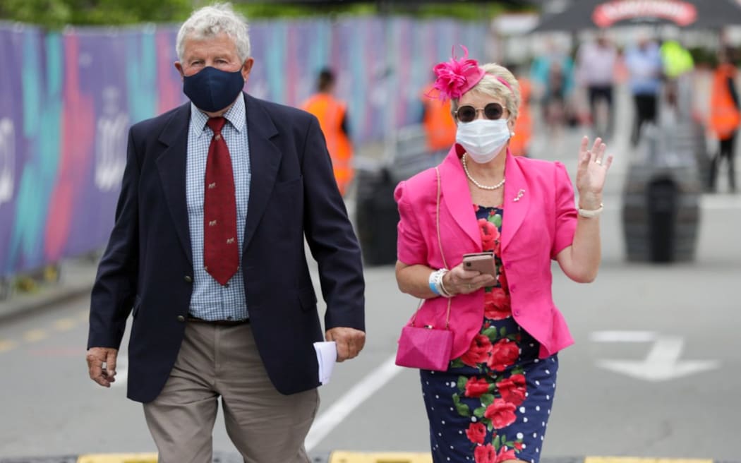 A couple arrive at Cup Day at Addington when numbers hugely restricted cos of Covid