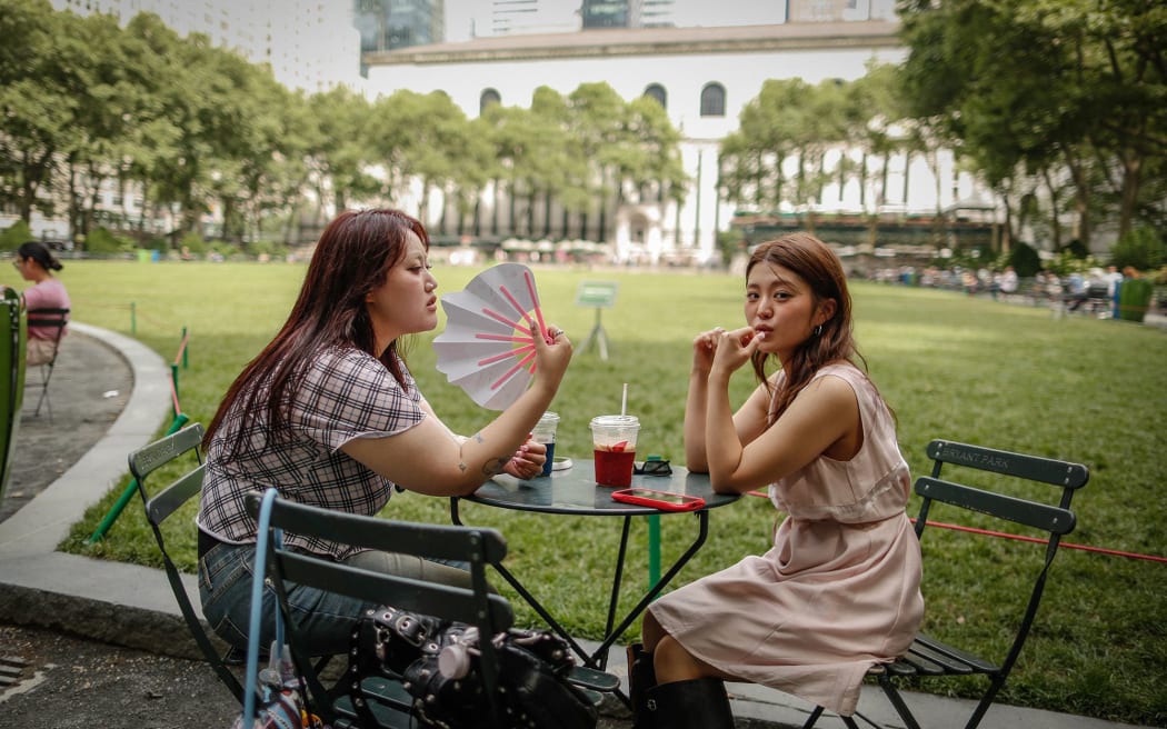 A woman holds a fan during a heat wave in New York City, on Sunday.
