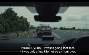 View from the driver's seat of a police car, the police officer apprehending a speeding driver.