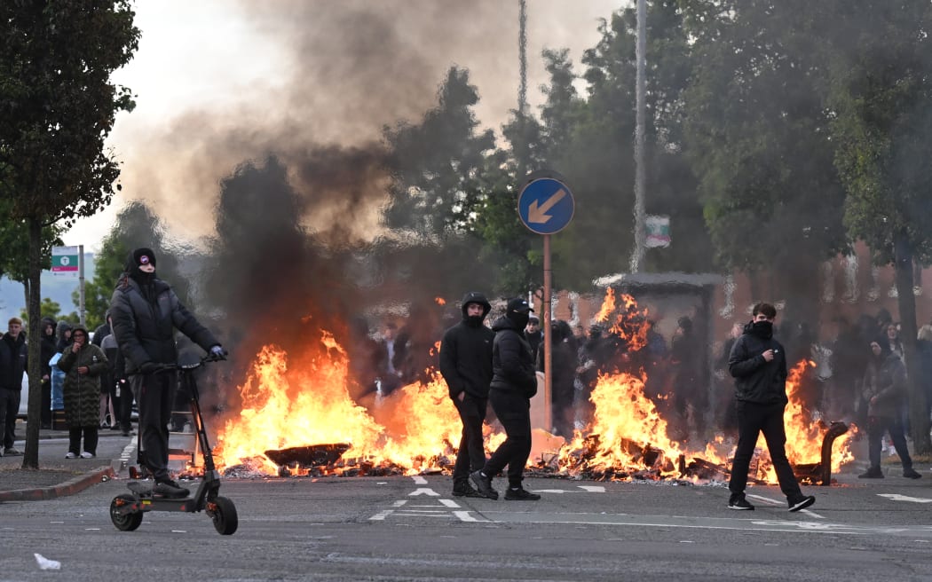 Homes and buses torched, roads blocked in Belfast anti-immigration protests | RNZ News